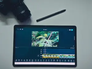 A tablet showing a video editing app on a desk
